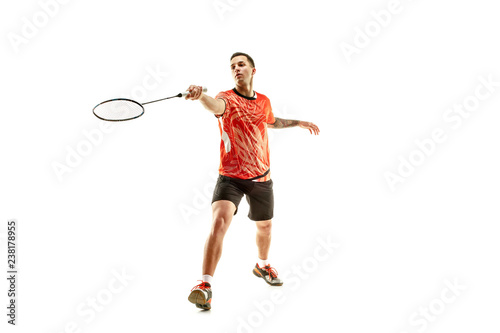 Young man playing badminton over white studio background. Fit male athlete isolated on white. badminton player in action, motion, movement. attack and defense concept
