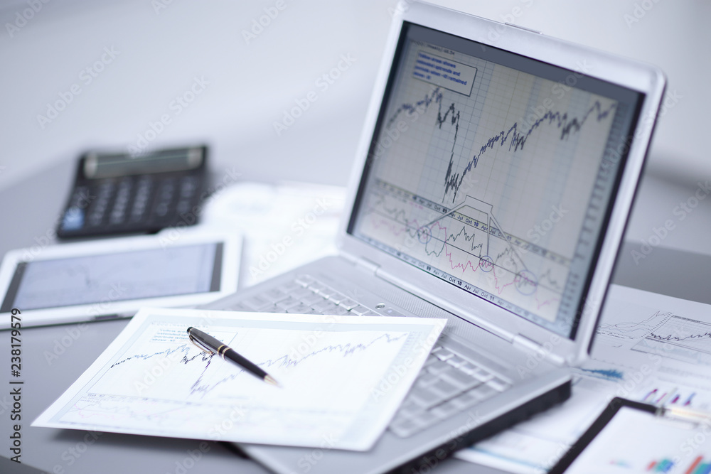 Close up of laptop with business chart at workplace. Accounting and report concept Close up of laptop with business chart at workplace. Accounting and report concept