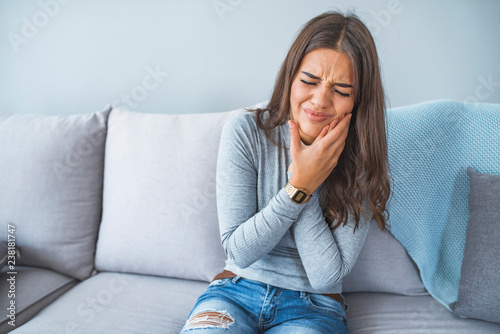 Portrait of a young woman in pain with a toothache photo