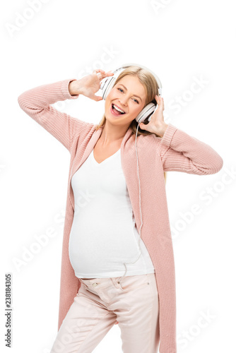 happy pregnant woman dancing with headphones isolated on white