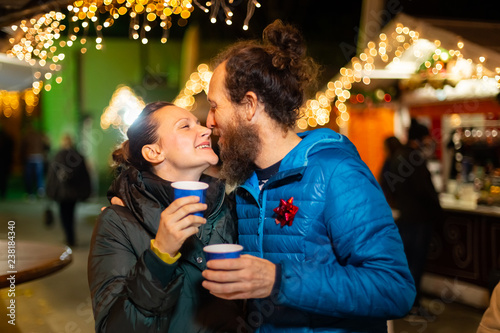 Couple kissing and enjoying traditional Christmas market, Zagreb, Croatia.
