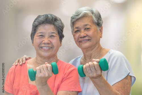 Senior elderly Asia woman hand holding dumbbell in physical therapy session. Healthy old people concept.