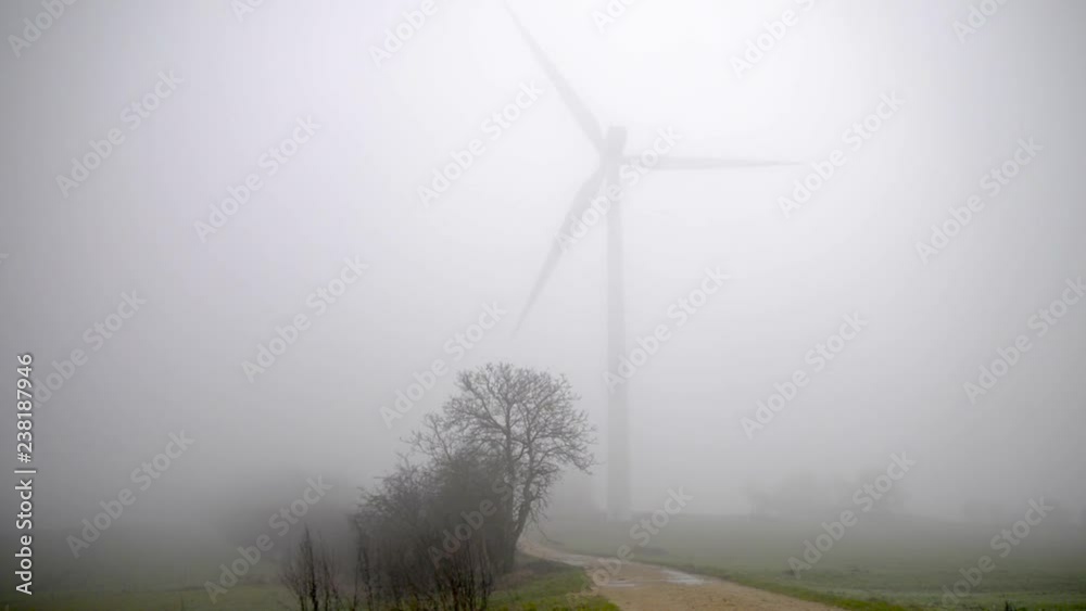 Vidéo d'une éolienne tournant en boucle dans la brume d'une campagne
