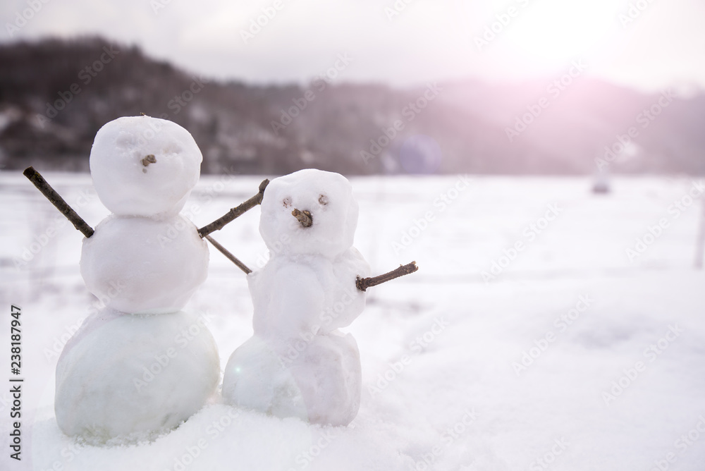 Two real tiny, little snowman in nature in snowy, cold day in mountains. Concept of beautiful winter and kids or family having fun on holidays. Merry Christmas. Two real tiny, little snowman in nature in snowy, cold day in mountains. Concept of beautiful winter and kids or family having fun on holidays. Merry Christmas.