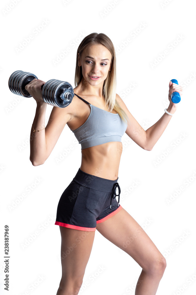 Beautiful young slim girl with dumbbells on a white background. Novice athlete Beautiful young slim girl with dumbbells on a white background. Novice athlete