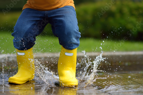Toddler jumping in pool of water at the summer or autumn day