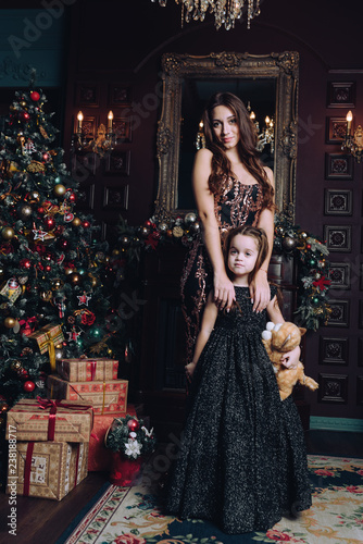 mother and daughter posing with christmas tree