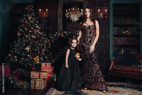 mother and daughter posing with christmas tree