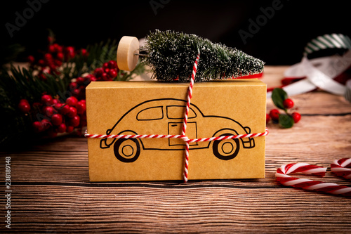 Prezent świąteczny. Świąteczny prezent z symbolem samochodu na drewnianym stole, kompozycja z miejscem na tekst.