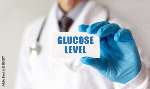 Doctor holding a card with text Glucose Level, medical concept