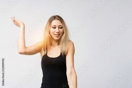 Concept portrait of a beautiful blonde girl smiling on a white background advertises product. She is right in front of the camera and shows different emotions.