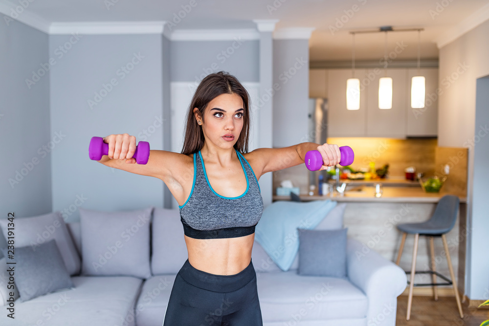 Fitness, sport, training and lifestyle concept - smiling woman with dumbbells exercising at home Fitness, sport, training and lifestyle concept - smiling woman with dumbbells exercising at home