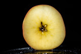 half of ripe apple on black background