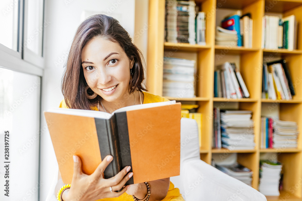Asian mixed race woman reading book in library, education and lifestyle concept Asian mixed race woman reading book in library, education and lifestyle concept