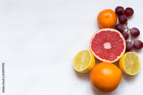 Various citrus fruits on white background, top view, copy space