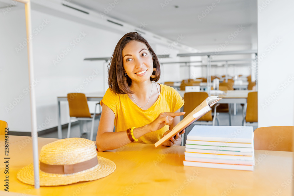 Asian mixed race woman reading book in library, education and lifestyle concept Asian mixed race woman reading book in library, education and lifestyle concept