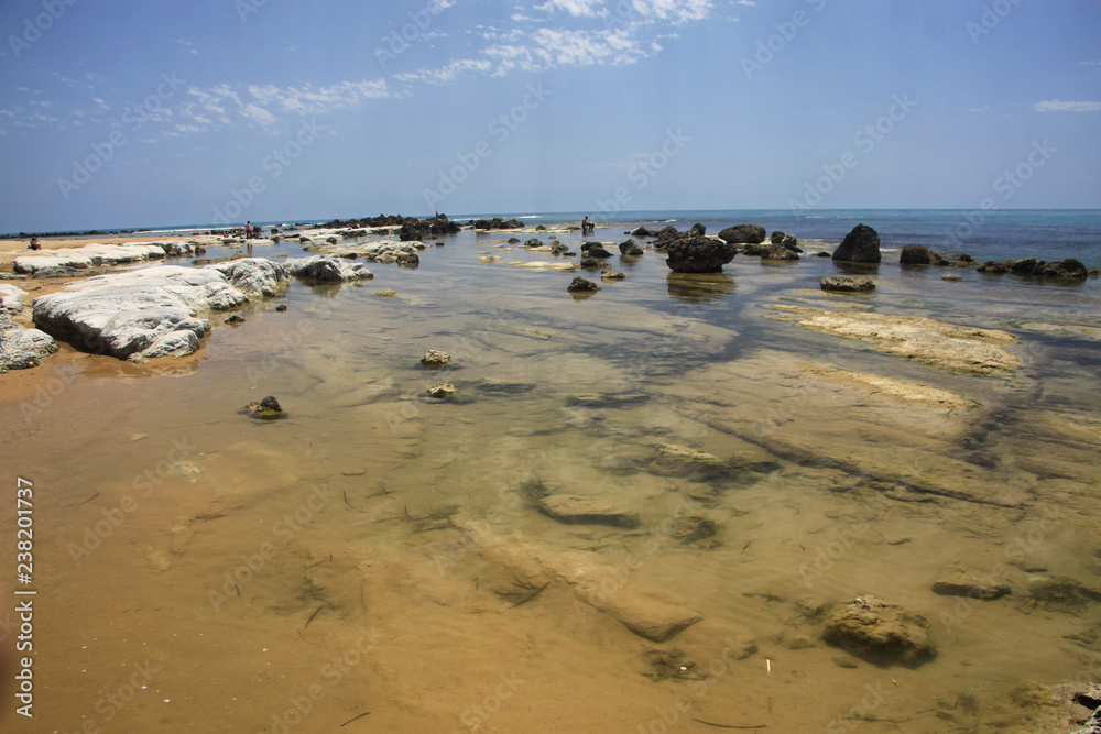 skały i kamienie wystające z morza przy brzegu scala dei turchi na sycylii