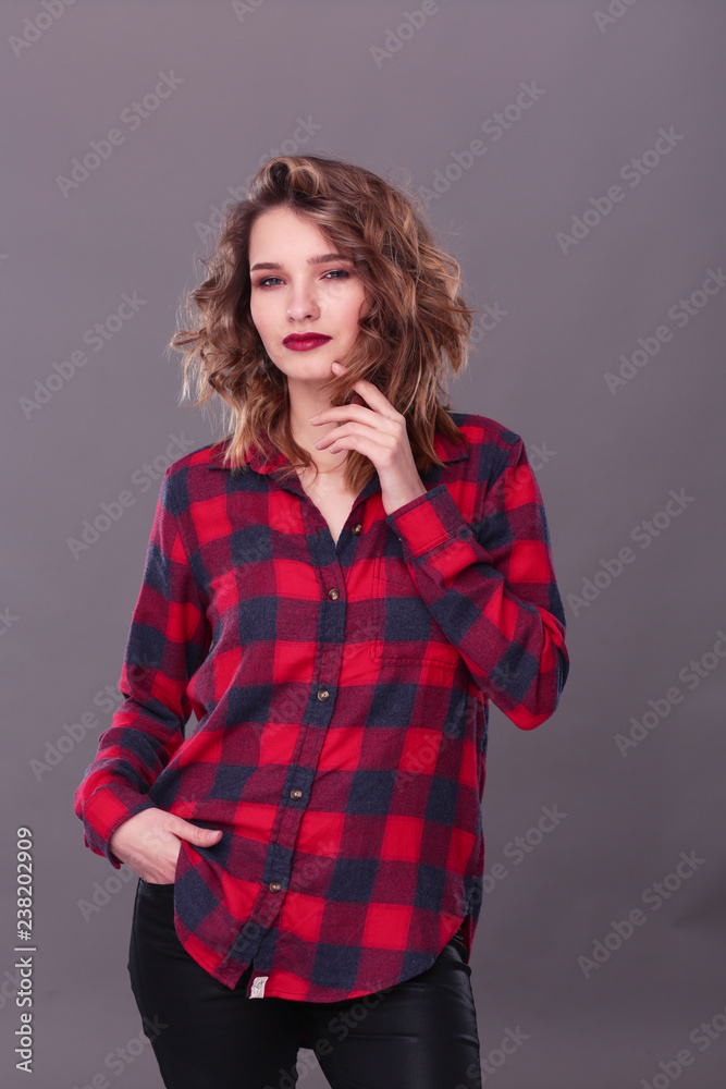 Young woman standing, isolated on gray background. Young woman standing, isolated on gray background.