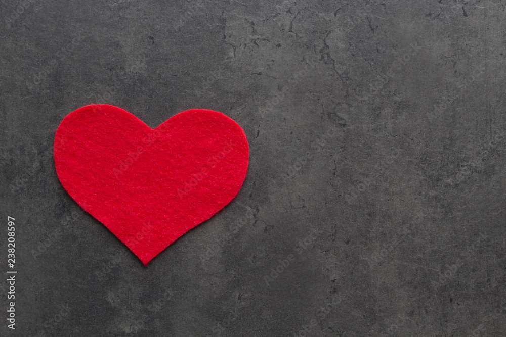 Heart carved from red felt on the grey concrete background. Love concept for Mother's day and St. Valentine's day. Top view, flat lay, copy space Heart carved from red felt on the grey concrete background. Love concept for Mother's day and St. Valentine's day. Top view, flat lay, copy space