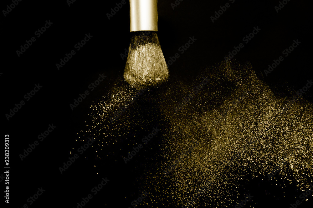 Obraz premium gold powder splash and silver brush for makeup artist or beauty blogger in black background, look like a luxury mood.