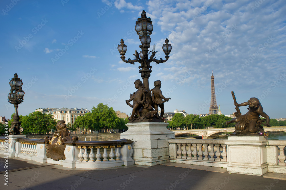 PARIS, FRANCE - MAY 26, 2018: Sculptures on Pont Alexandre III. View of the Bridge of Invalids and the Eiffel Tower.