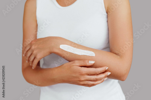Closeup of female hands applying hand cream.Hand Skin Care. Women use body lotion on your arms. Beauty And Body Care Concept