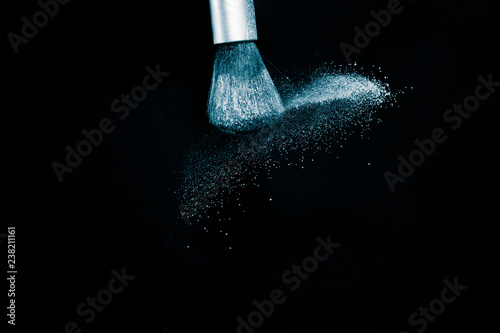 Deep ocean powder color splash and silver brush for makeup artist or beauty blogger in black background, look like a look like a cold and calm mood.