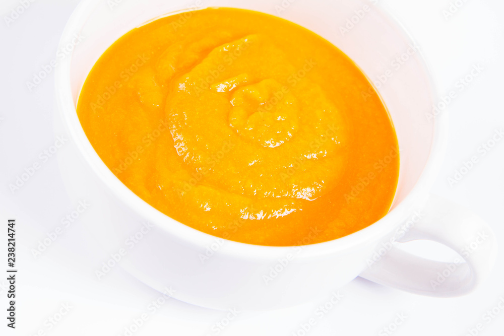 Pumpkin soup in a bowl on a white background