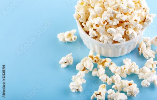 Popcorn on a bright blue background. Film. Fast food. Corn