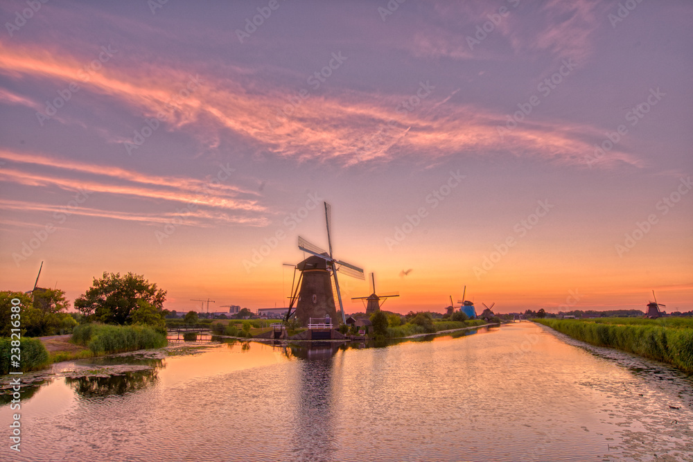 view of traditional windmills at sunset in Kinderdijk, The Netherlands.