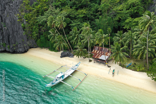 Aerial drone view of turquoise coastal waters and limestone cliffs in El Nido archipelago tourist destination. El Nido, Palawan, Philippines. photo