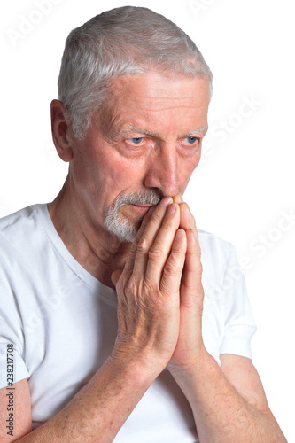 Portrait of senior man praying on white background