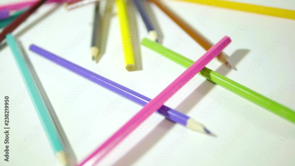 Pencil on a white background. Camera in motion. Colored pencils are in a chaotic manner