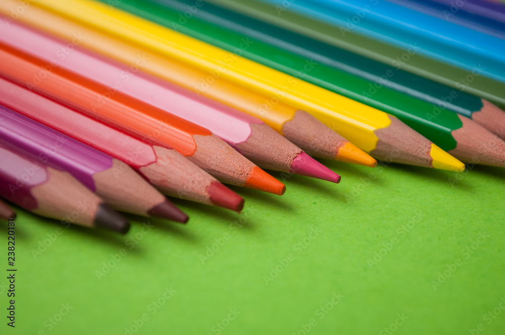 Fototapeta premium closeup of colouring pencils on green background