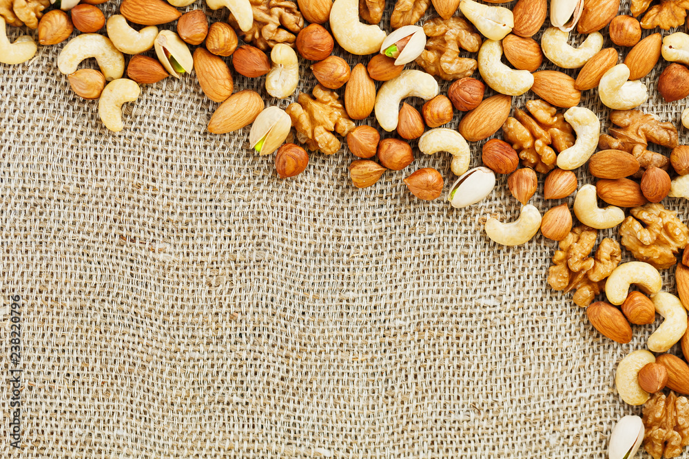 Mix of nuts lying on a background of brown cloth burlap. Mix of nuts lying on a background of brown cloth burlap.