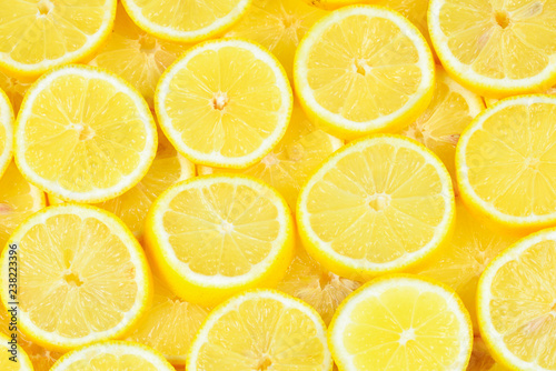 A slices of fresh juicy yellow lemons. Texture background, pattern.