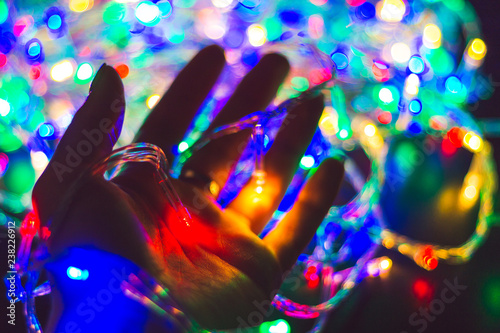 Hand holds fire of christmas garland. Festive mood, christmas, background,