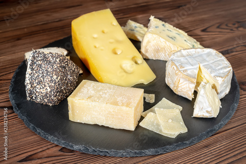 delicious various types of cheese on slate stone background