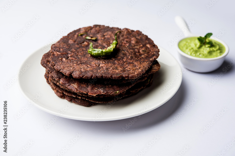 Ragi roti or flat Bread made using finger millet is a healthy and tasty breakfast dish of Karnataka, India. served with green chilli and chutney. selective focus Ragi roti or flat Bread made using finger millet is a healthy and tasty breakfast dish of Karnataka, India. served with green chilli and chutney. selective focus