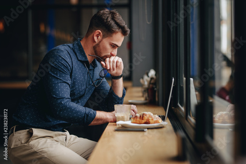 Businessman working on laptop sitting in a restaurant