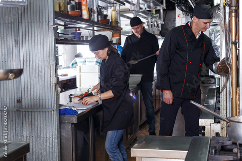 Friendly cooks in process of cooking dishes