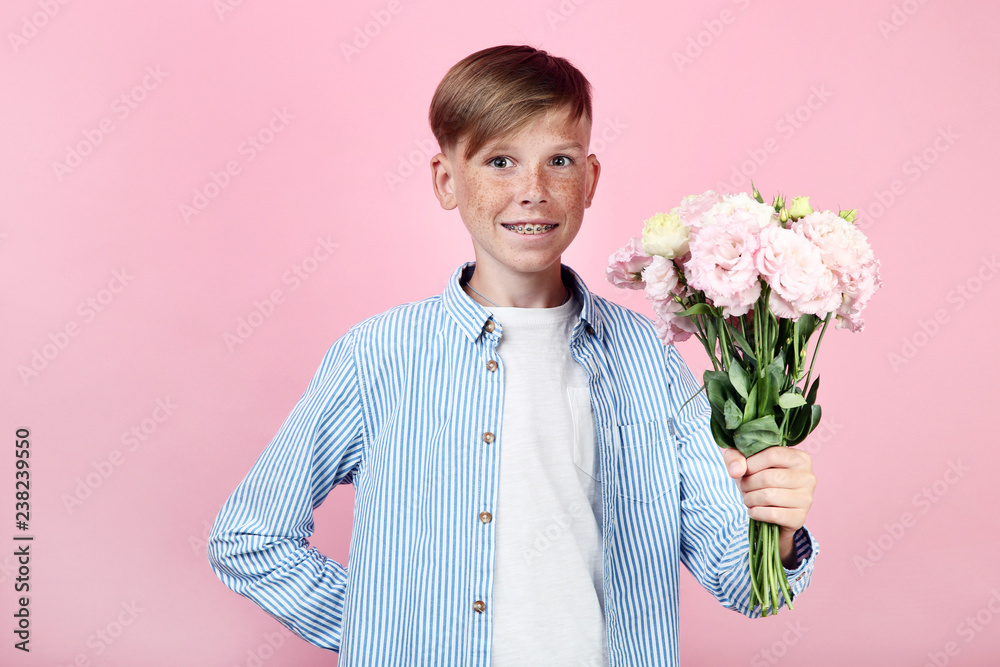 Beautiful young boy with eustoma flowers on pink background Beautiful young boy with eustoma flowers on pink background