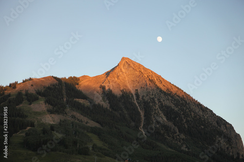 Moon over crested butte on a sunny summer day