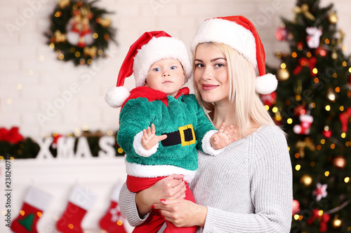 Mother and son in santa hats celebrate christmas at home