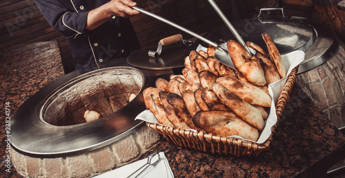 Foto Baker making turkish pita bread in tandoor (clay oven)