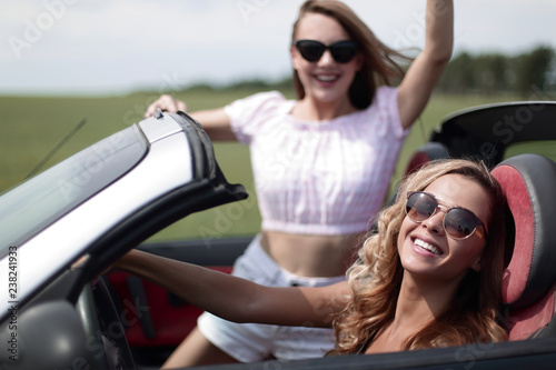 close up.two happy young women in a convertible car © ASDF