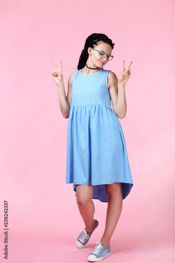 Young woman in blue dress on pink background Young woman in blue dress on pink background