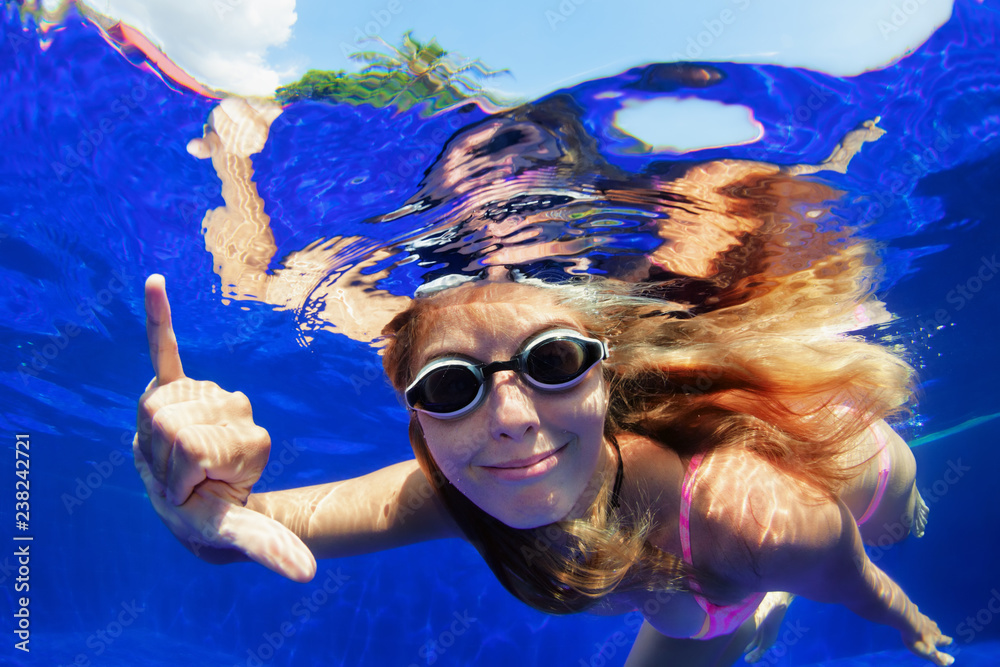 Happy family in swimming pool. Smiling woman in goggles swim underwater ...