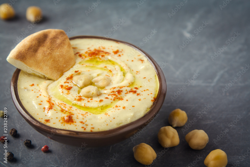Hummus plate and pita bread on dark background. Mediterranean snack, vegetarian healthy food concept. Top view, flat lay, copy space. Hummus plate and pita bread on dark background. Mediterranean snack, vegetarian healthy food concept. Top view, flat lay, copy space.