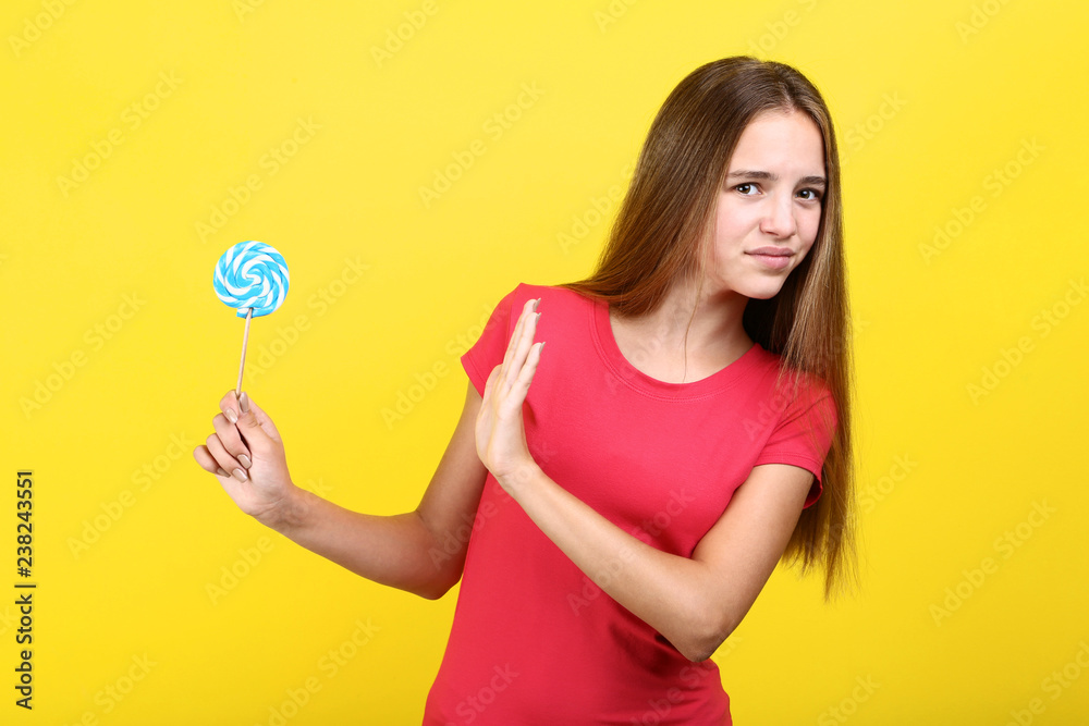 Young girl with lollipop on yellow background Young girl with lollipop on yellow background